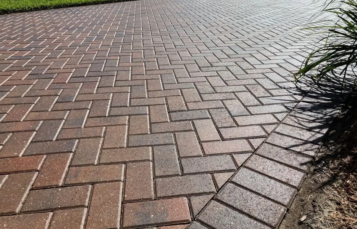 Close-up of herringbone brick paver pattern on municipal sidewalk surface